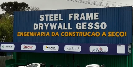 Fachada com superfície corrugada azul e identificação Steel Frame, Drywall e Gesso